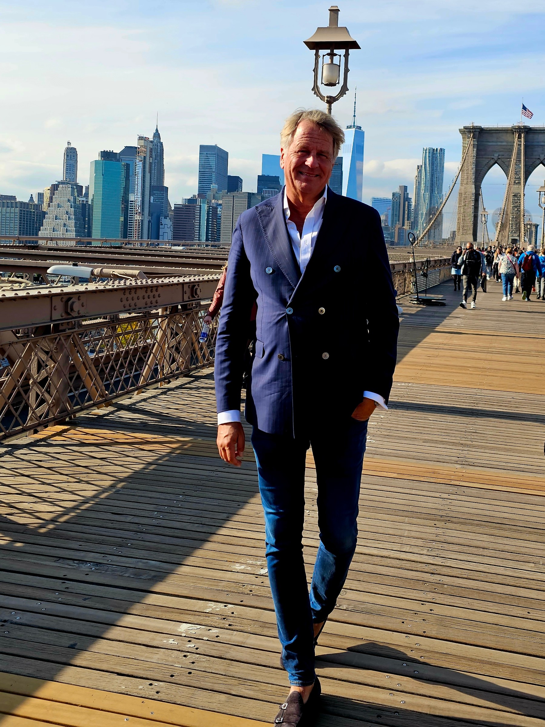 Lars Carlstrom on Brooklyn Bridge with the New York skyline behind him