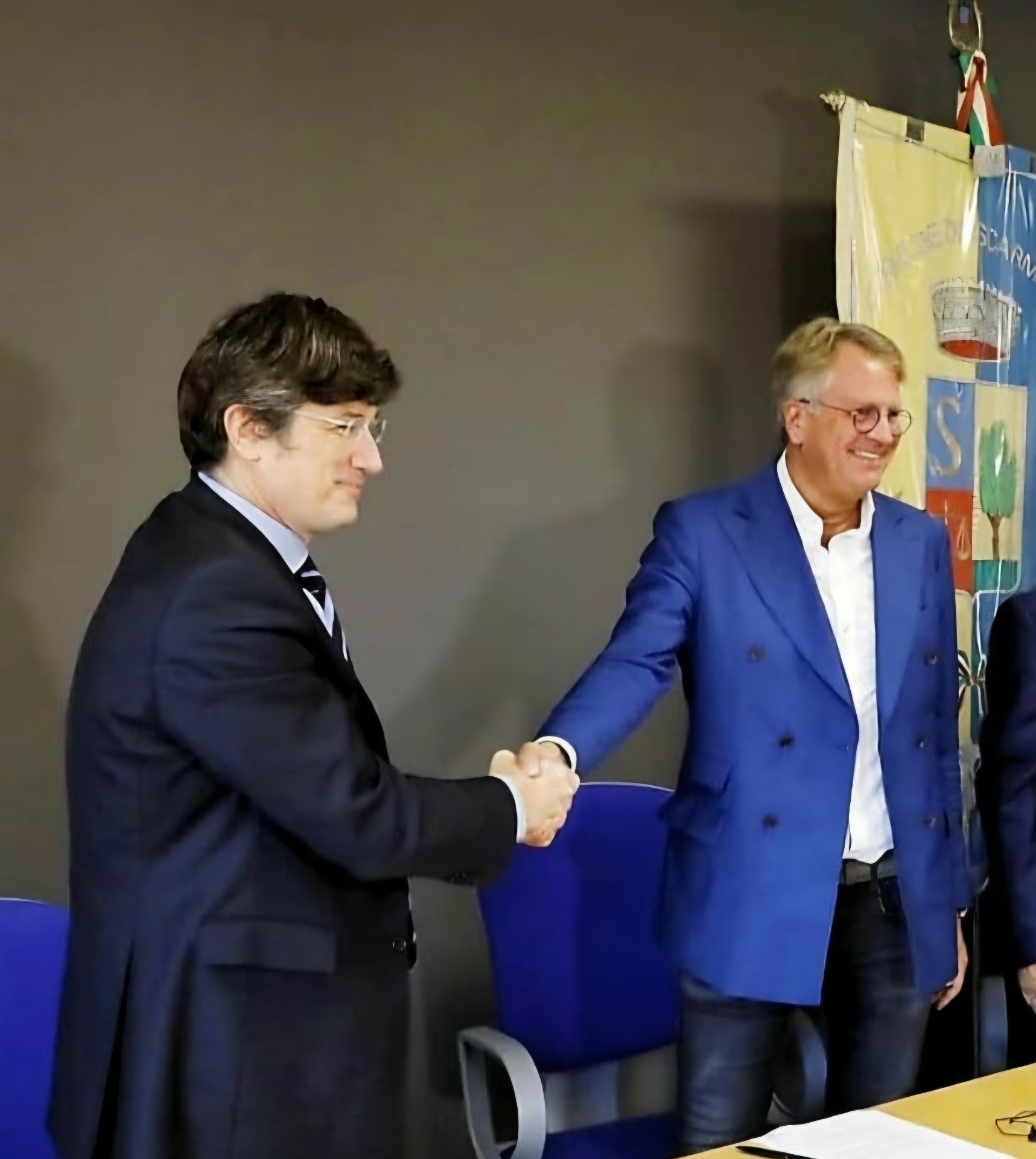 Lars Carlstrom in a blue jacket shaking hands at a meeting