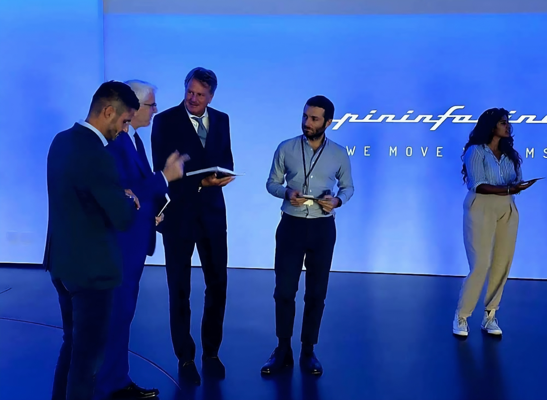Lars Carlstrom with a group in front of a blue Pininfarina backdrop