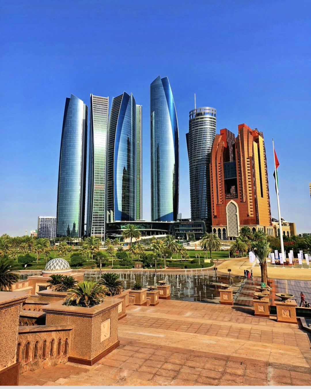 Abu Dhabi towers rising above landscaped gardens