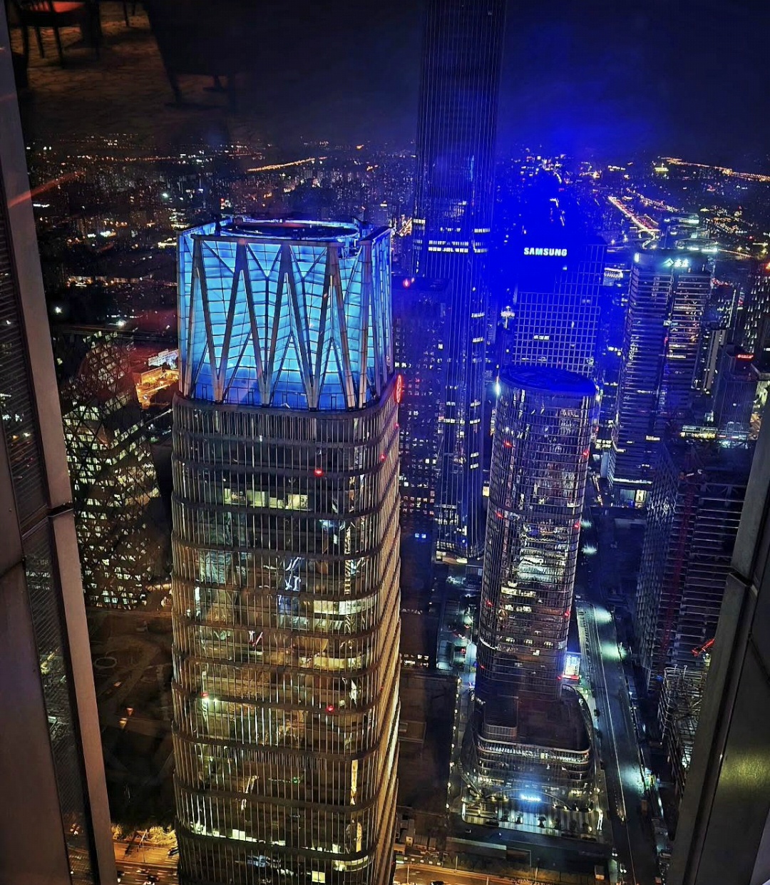 Illuminated high-rise buildings photographed through a window at night